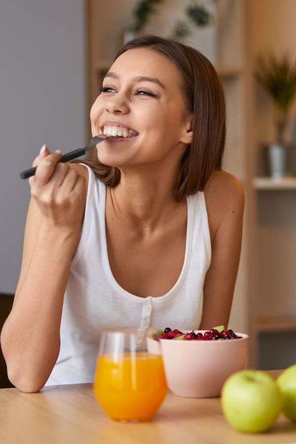 image of a woman in her kitchen enjoying a fruit bowl