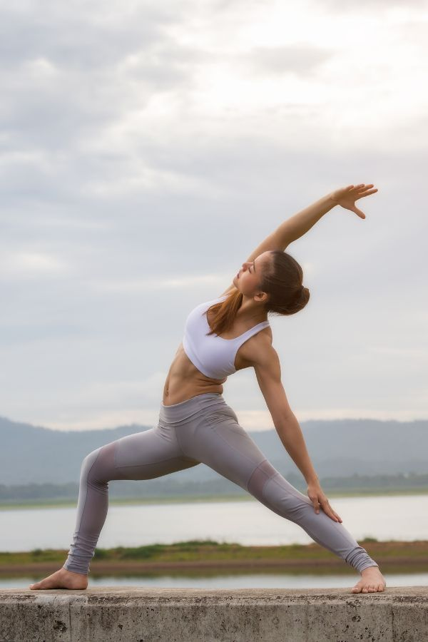 image of a woman holding a yoga pose near a lake